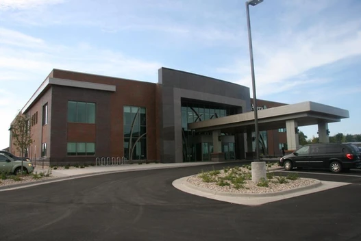 A large building with a parking lot in front of it.