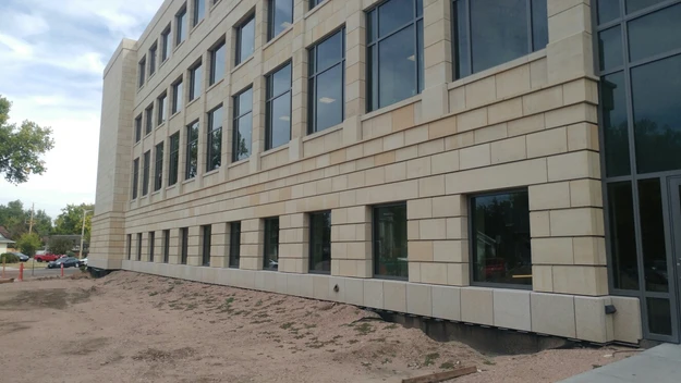 A building with many windows and sand on the ground.