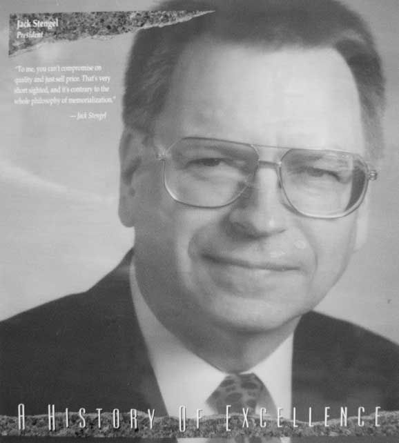 A man in glasses and suit jacket with newspaper.