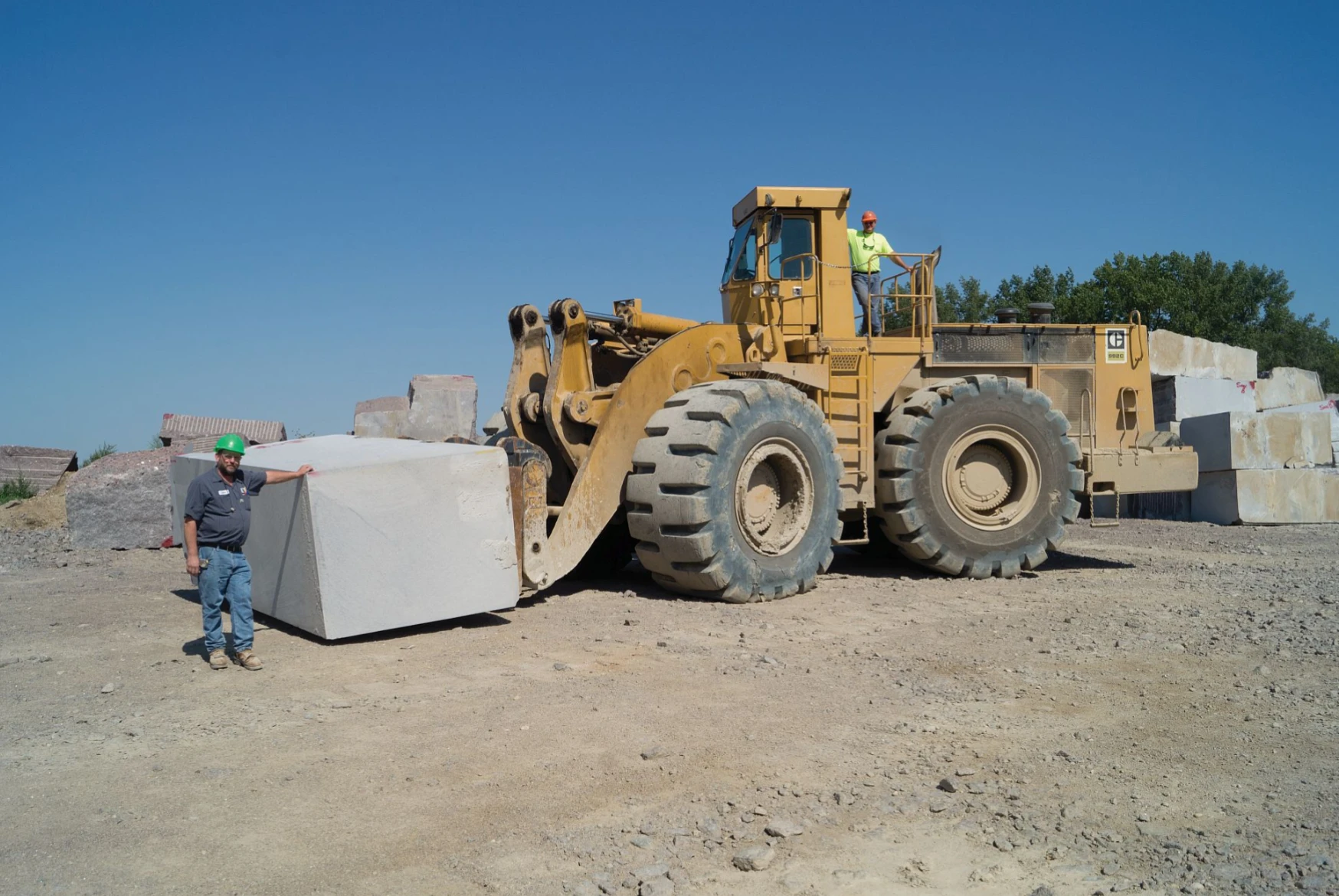 A large yellow tractor is pulling a block.