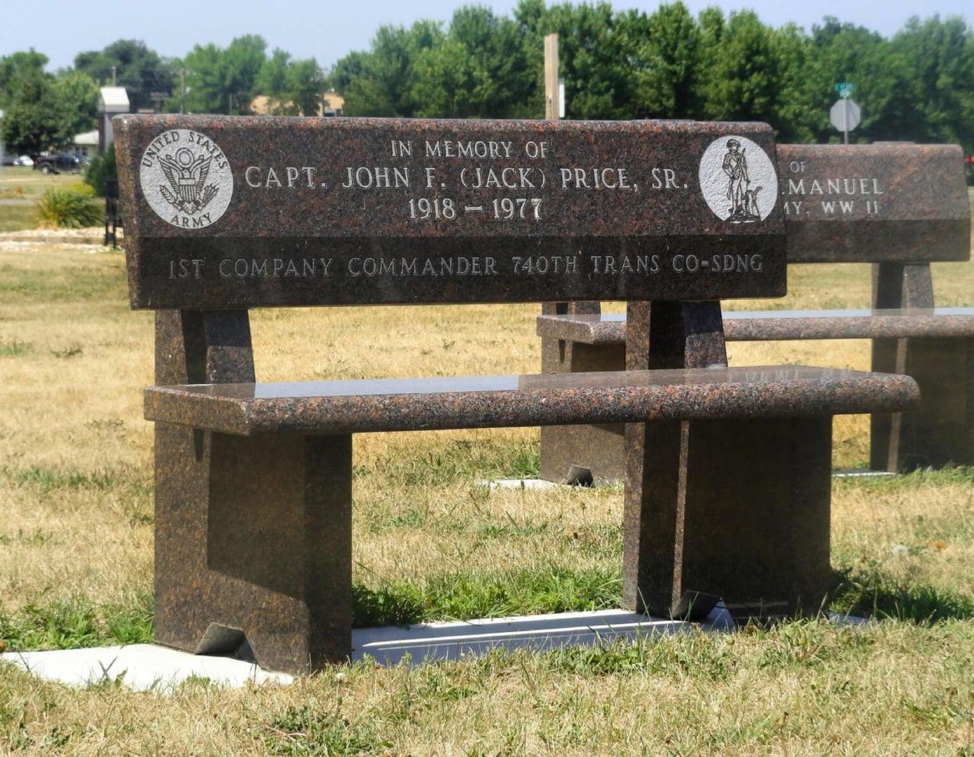 A bench in the middle of a field with two benches.