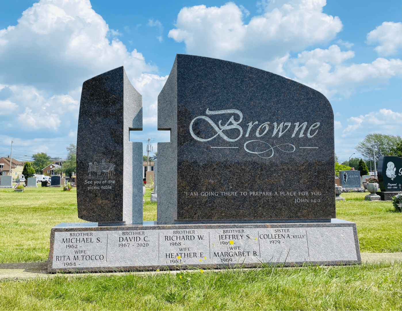 A black granite monument with a cross on top of it.